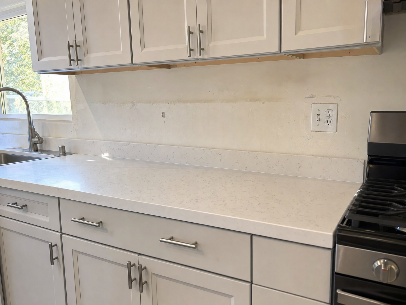 Kitchen before new backsplash — no tile